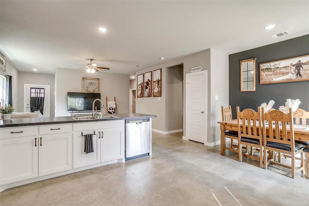 a large white kitchen with stainless steel appliances granite countertop a sink and cabinets