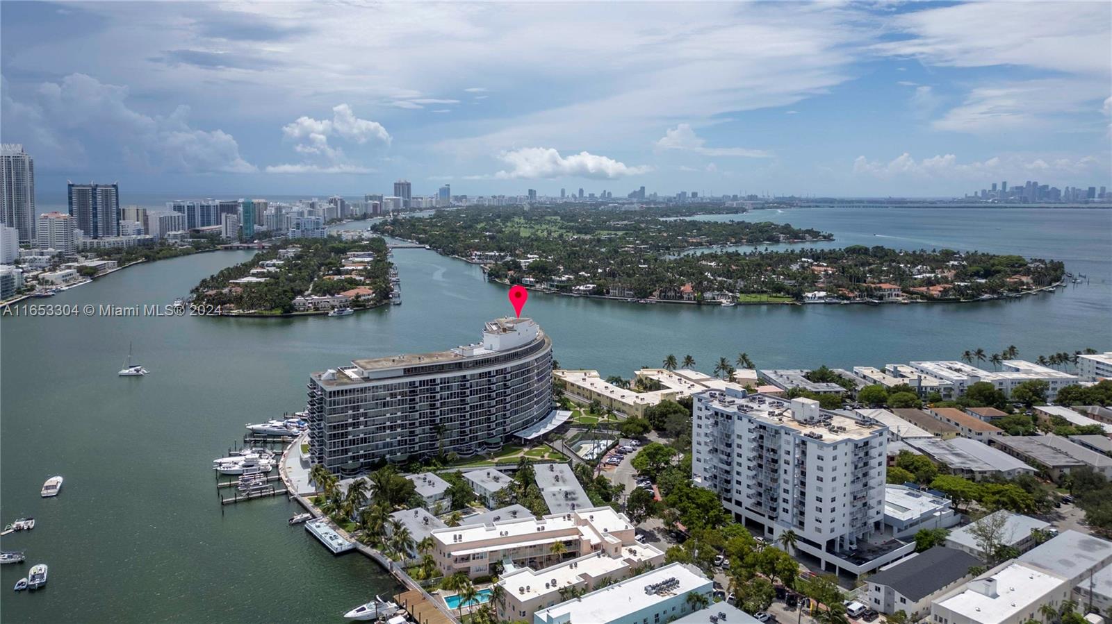 an aerial view of a city with lots of residential buildings ocean and mountain view in back