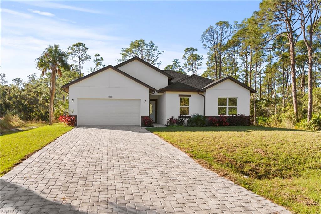 Ranch-style house with a garage and a front lawn