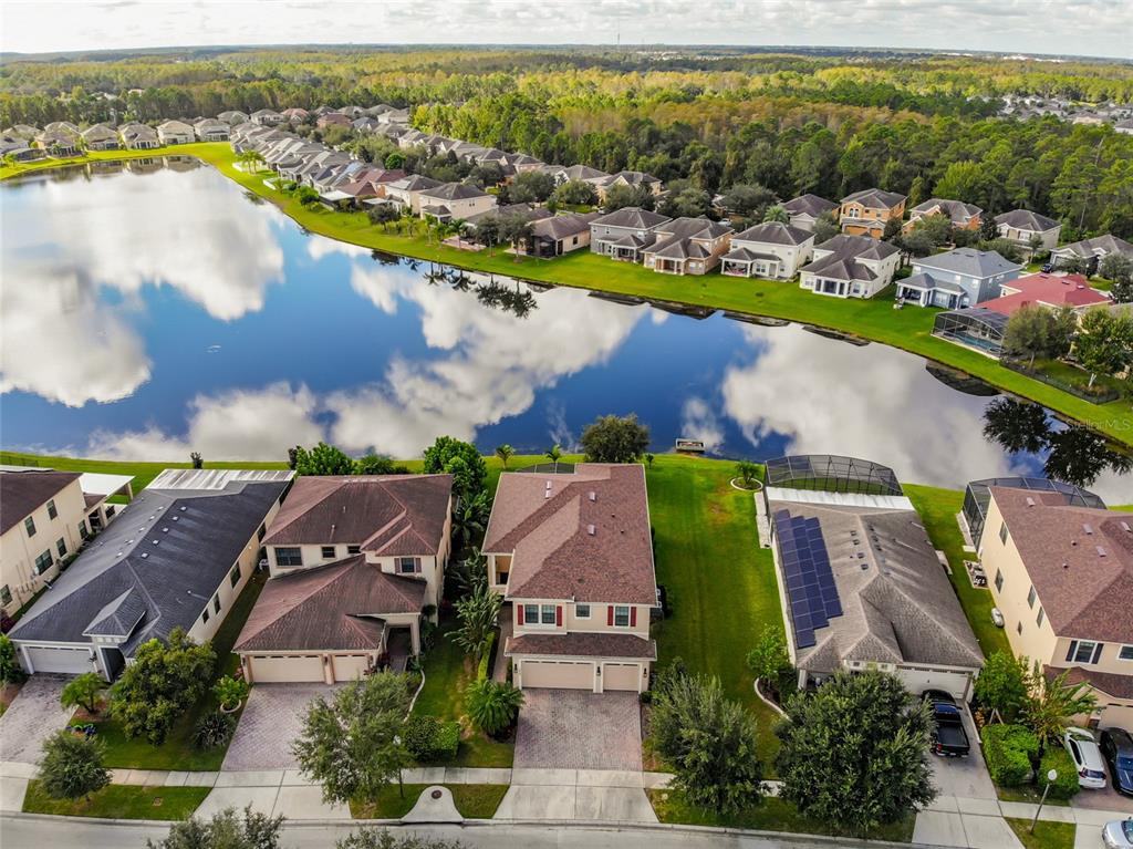 an aerial view of residential houses with outdoor space and lake view