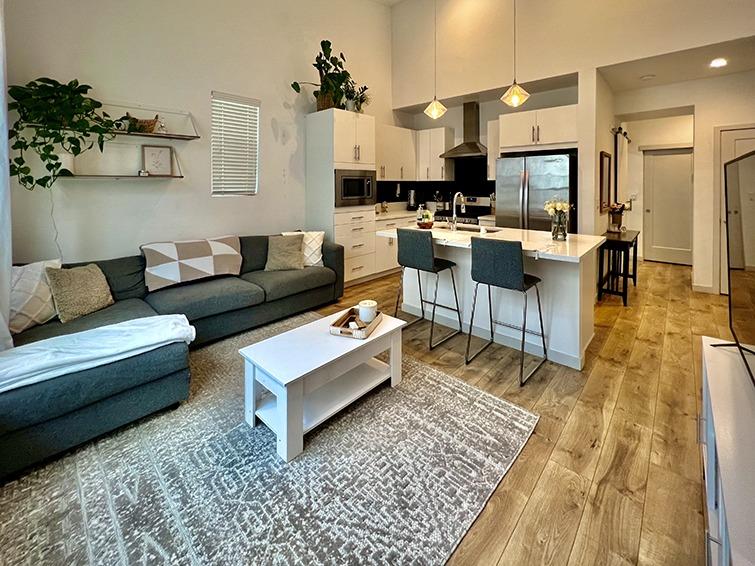 a living room with furniture and a kitchen view