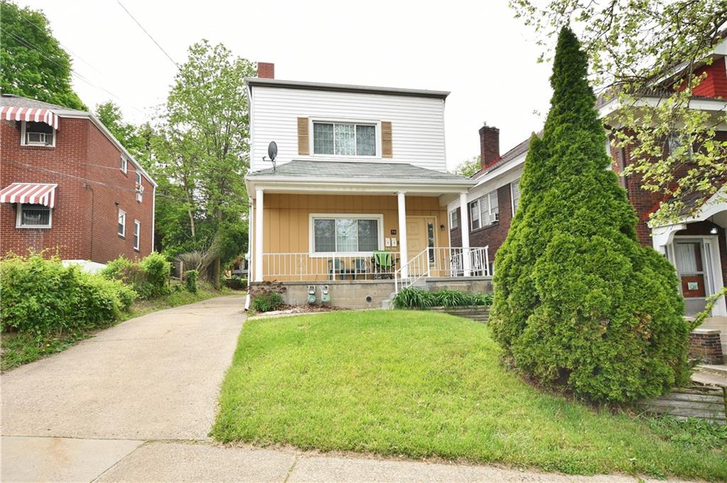 a front view of a house with yard and green space