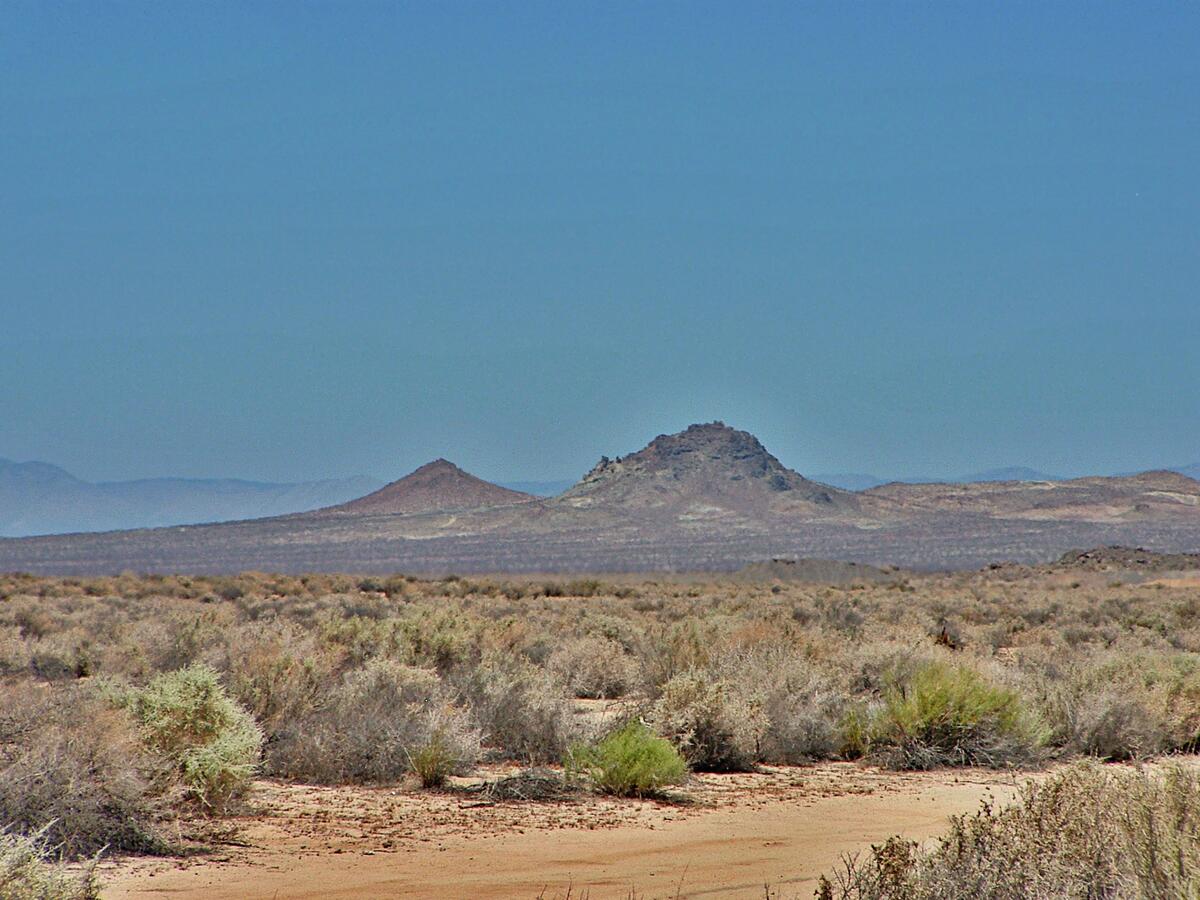 a view of a large mountain with mountains in the background