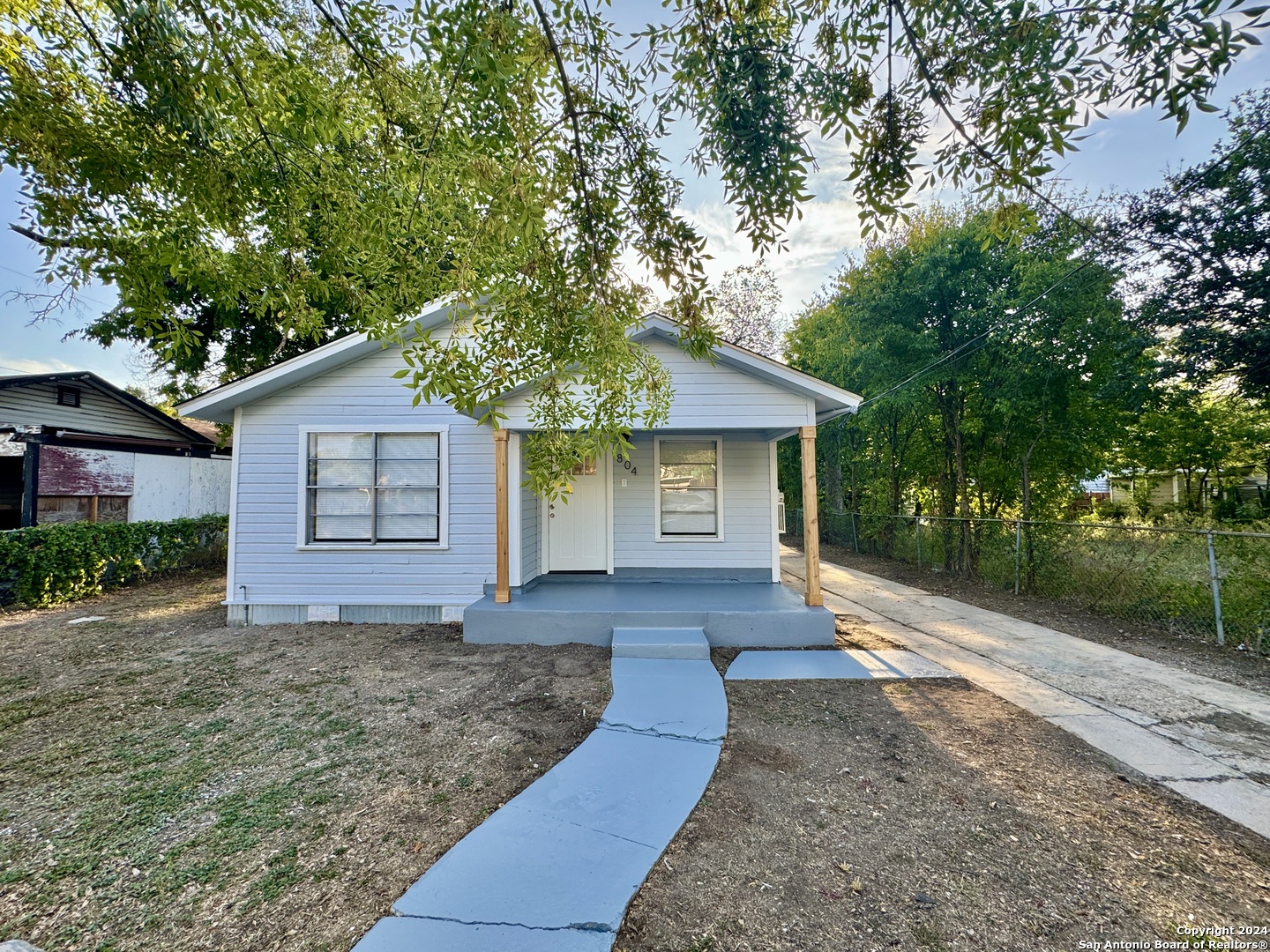 a front view of a house with a yard and tree