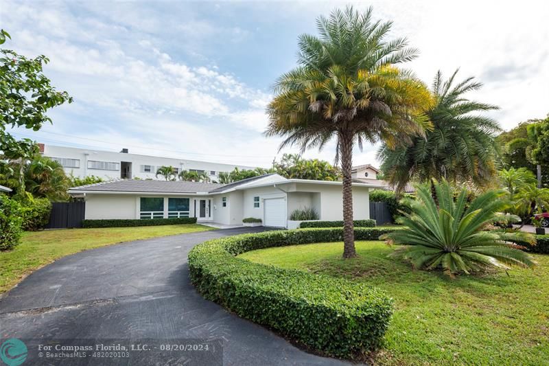 a front view of a house with a yard and palm tree