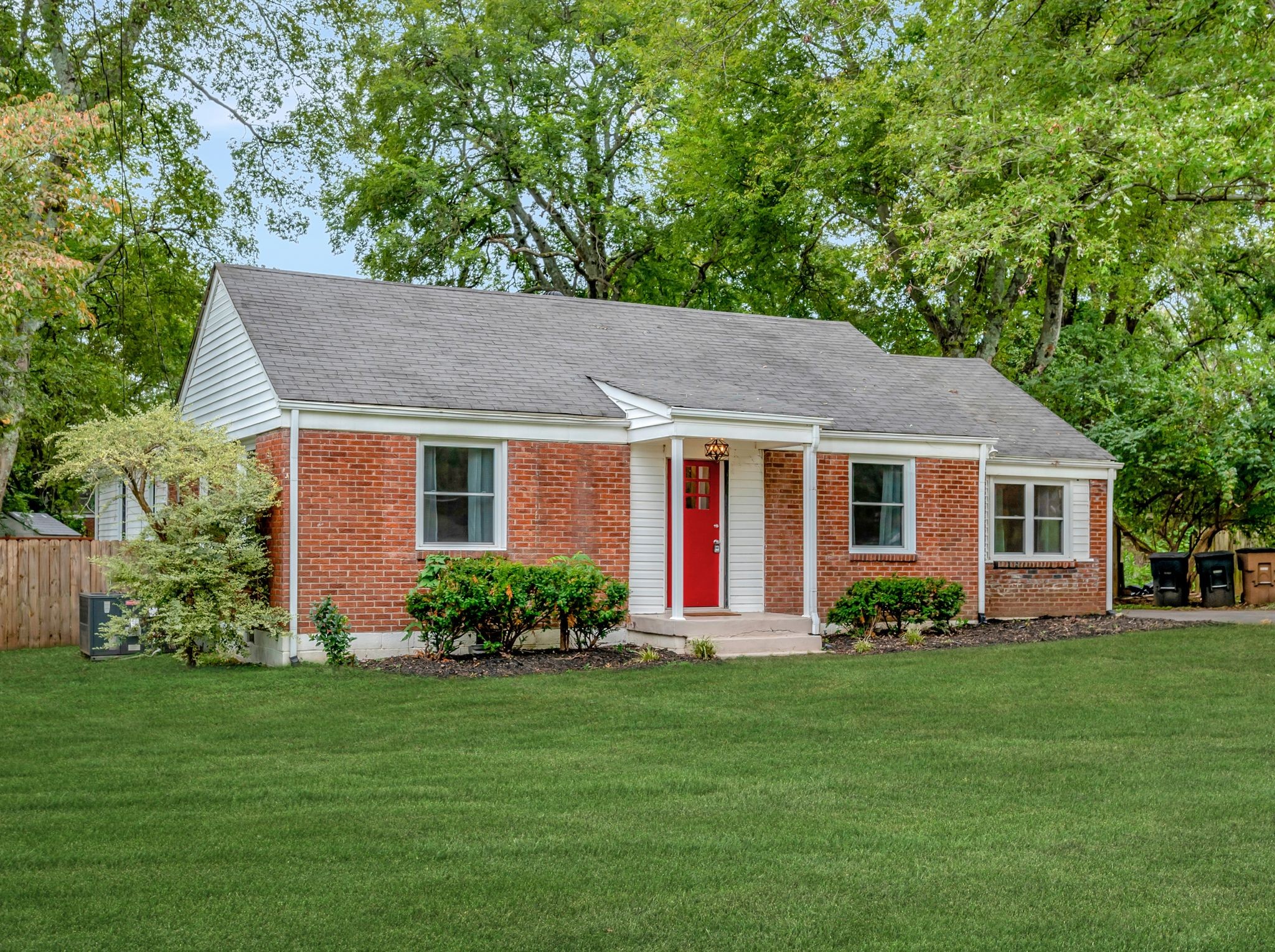 a front view of a house with a garden and plants