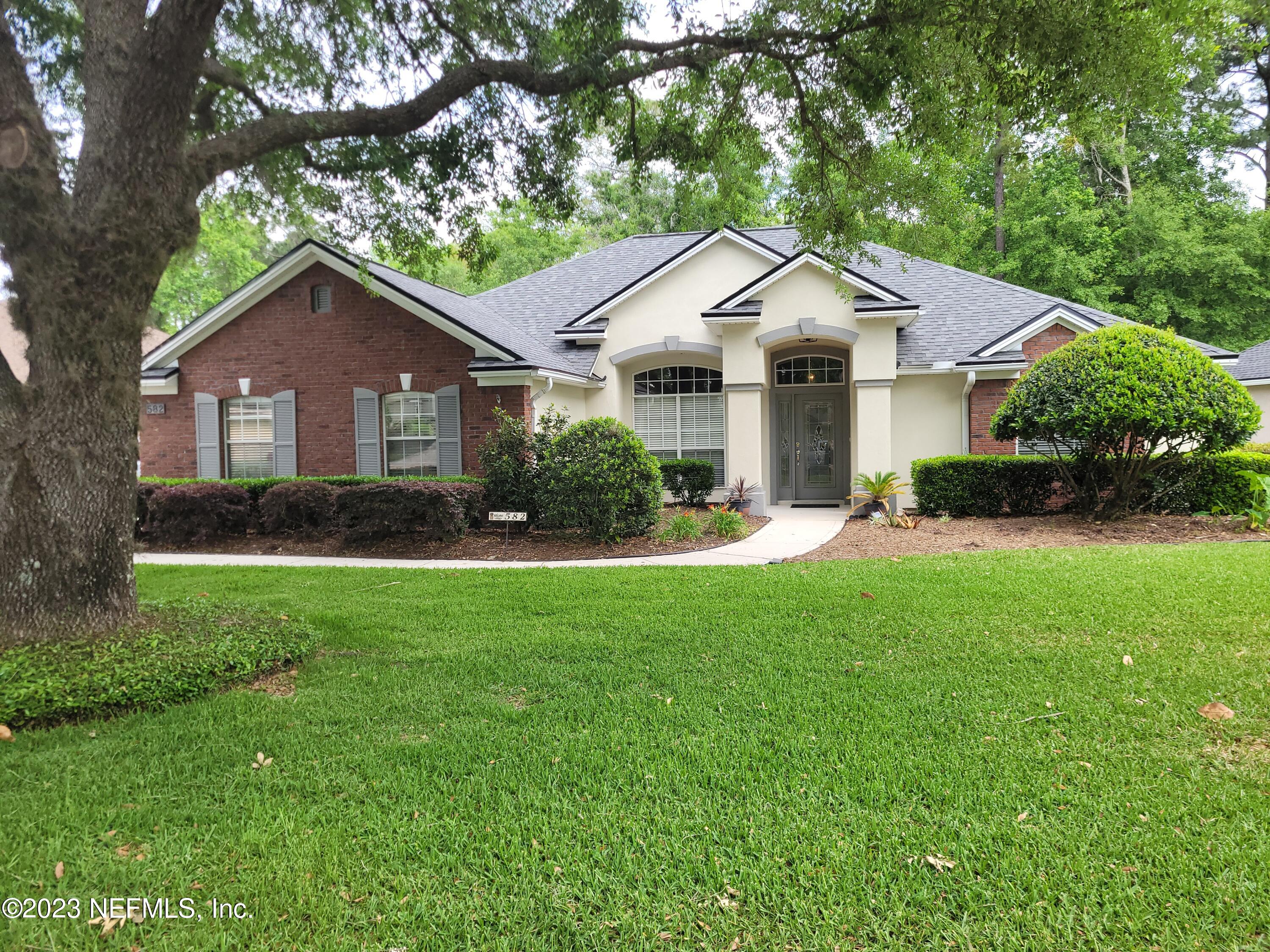 a front view of house with yard and green space