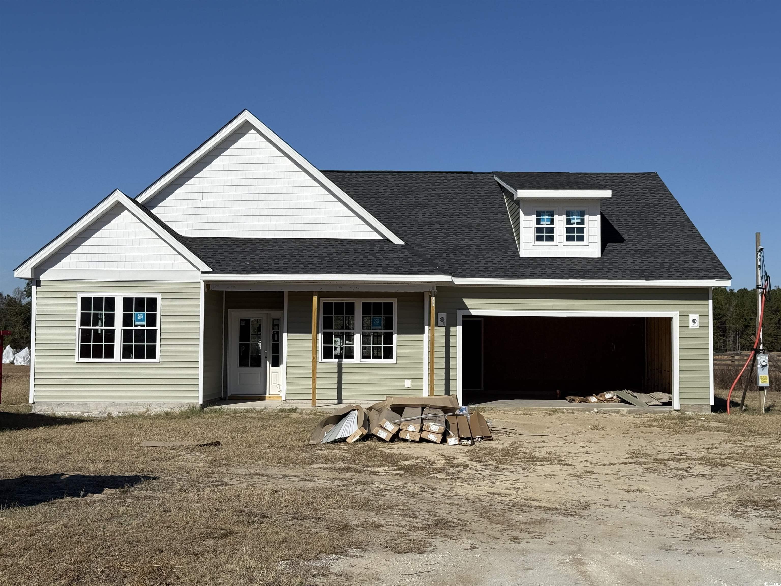 View of front of home featuring a porch and a gara