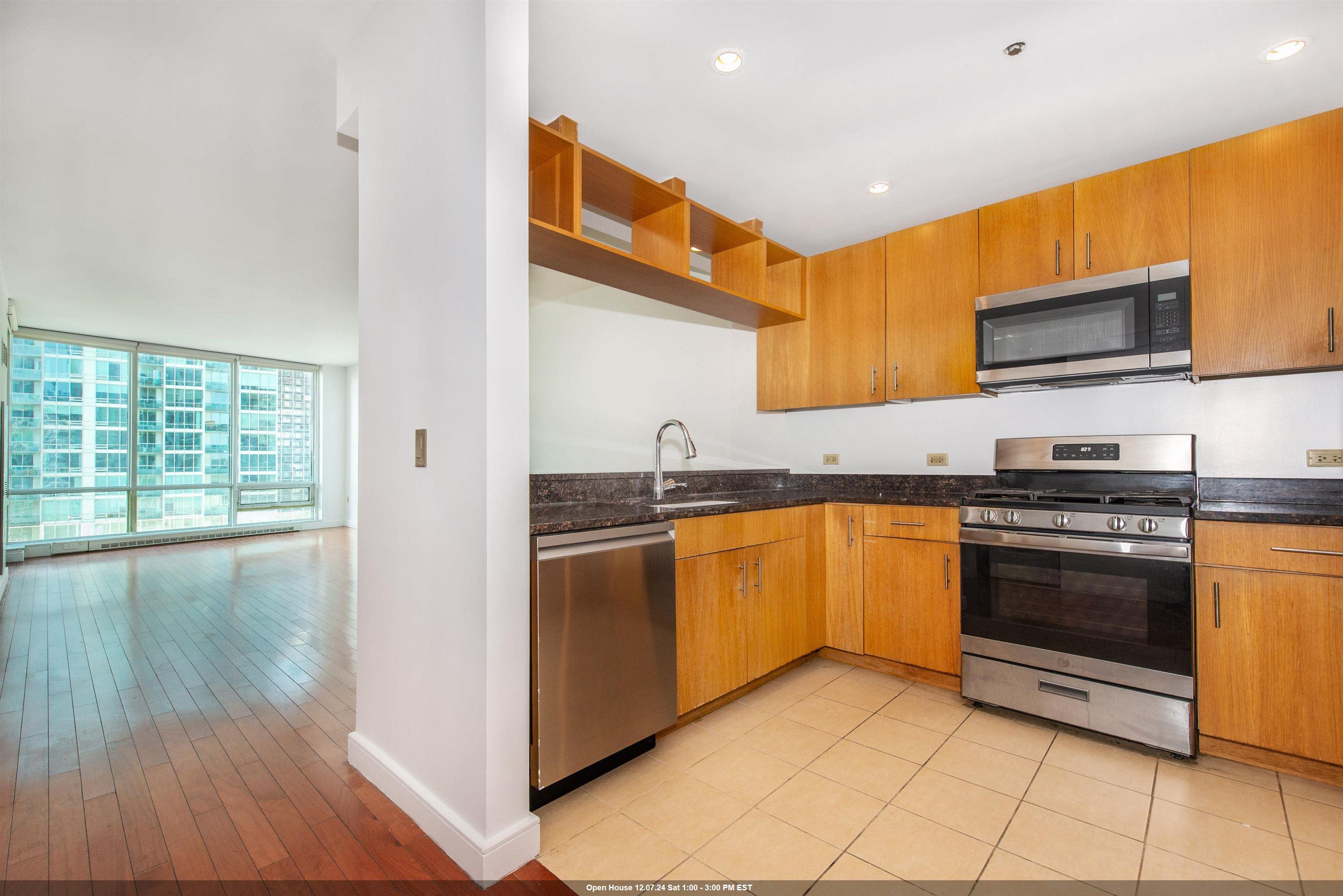 a kitchen with stainless steel appliances granite countertop a stove a sink and a microwave