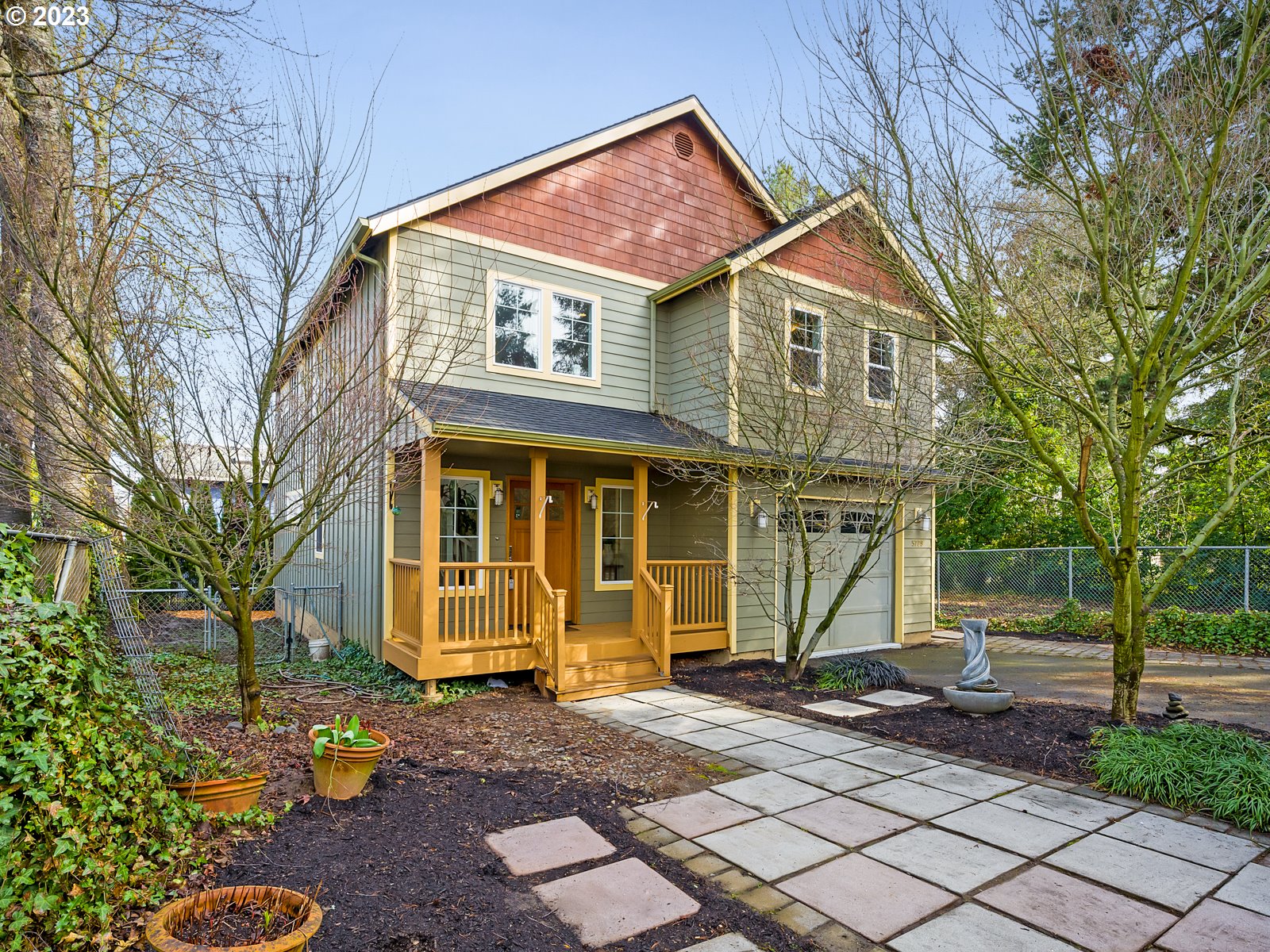 a front view of a house with a yard and potted plants