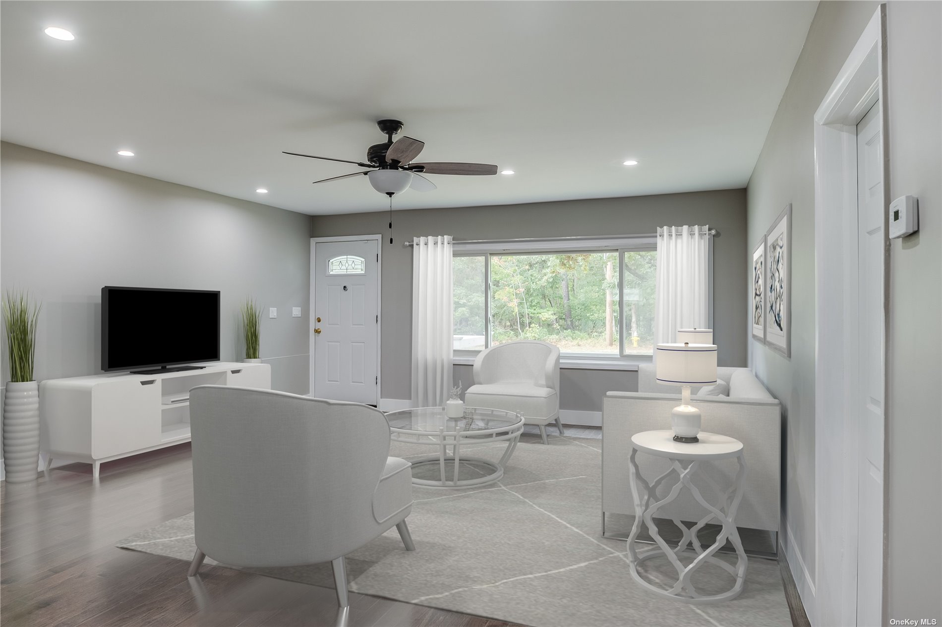 a living room with furniture a flat screen tv and a large window