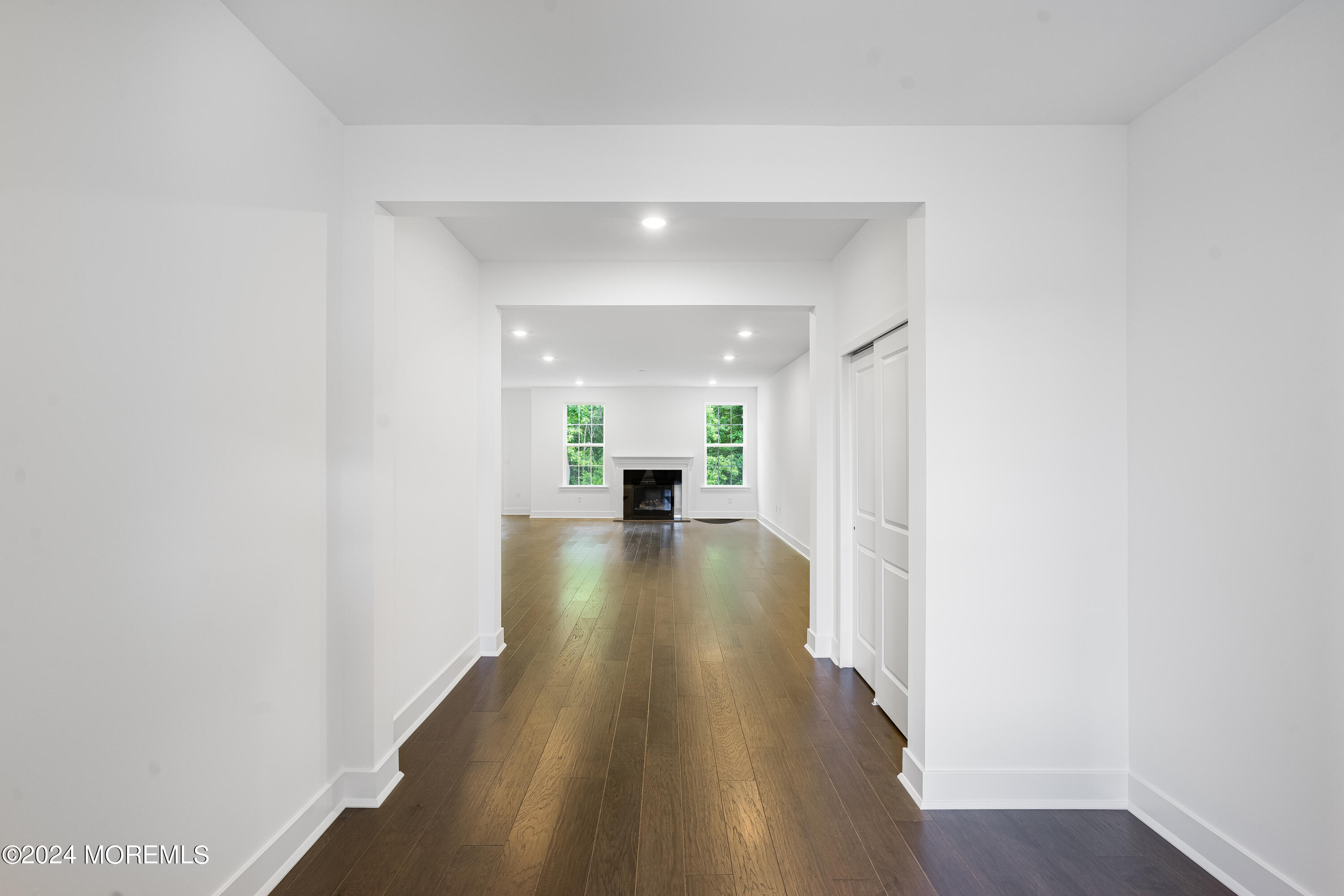 a view of a hallway with wooden floor a fireplace