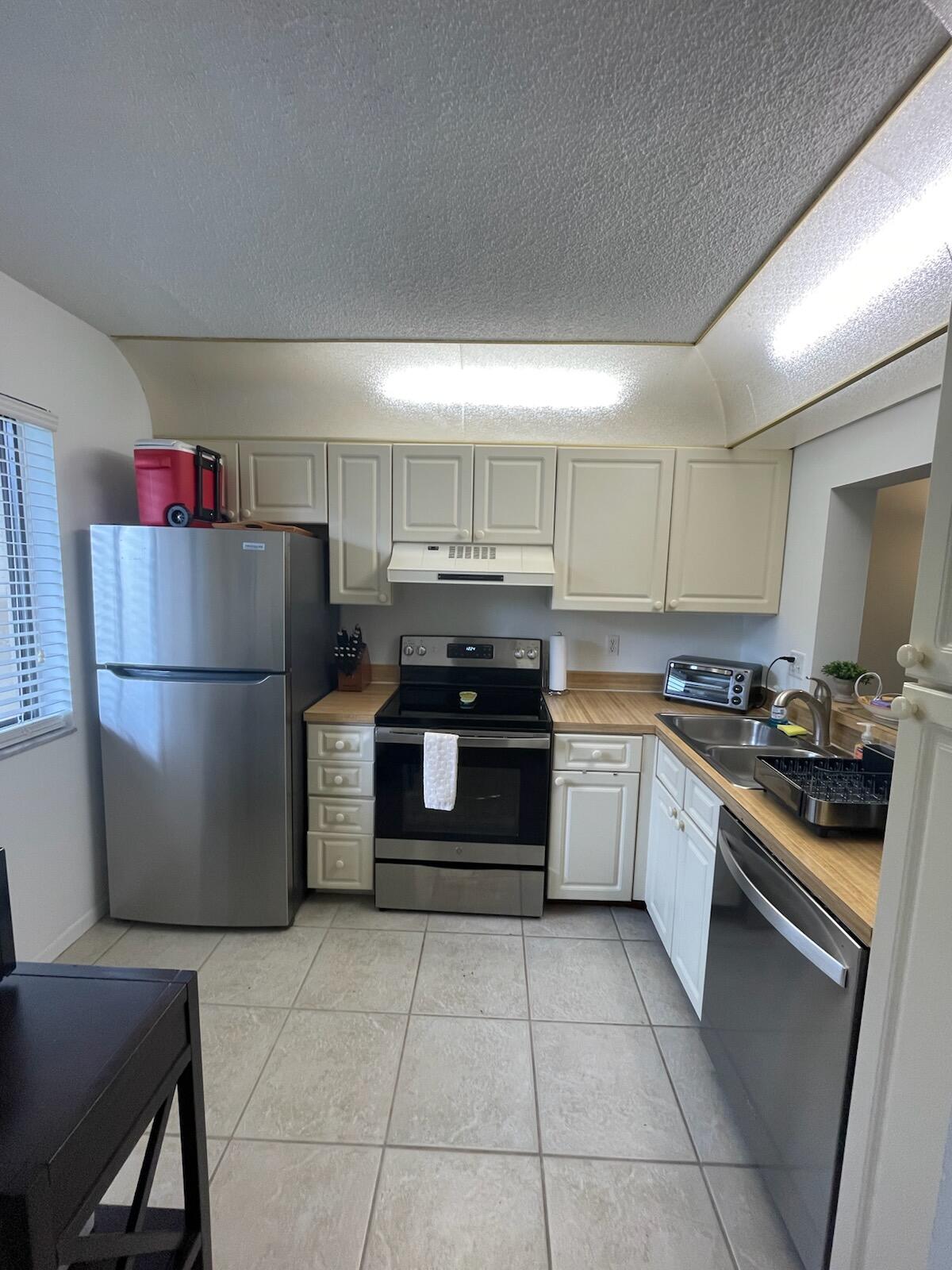 a kitchen with a refrigerator and a stove top oven