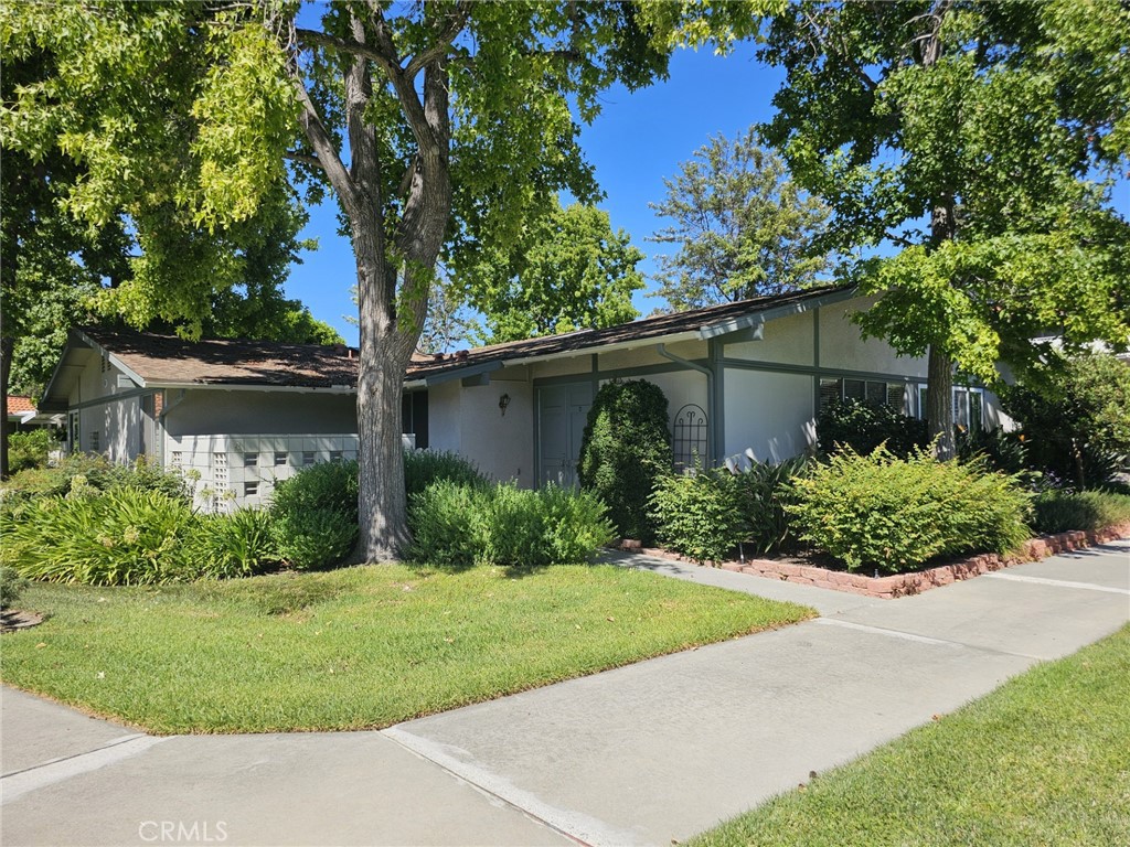 a front view of a house with a yard and potted plants