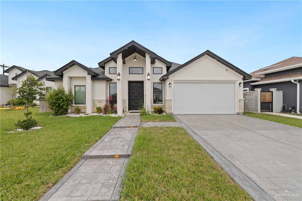 View of front of home with a garage and a front lawn