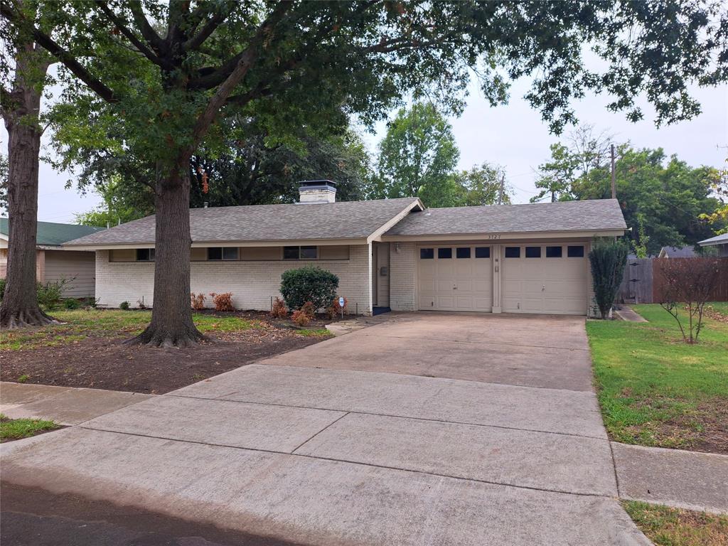 a view of a house with a yard and large tree