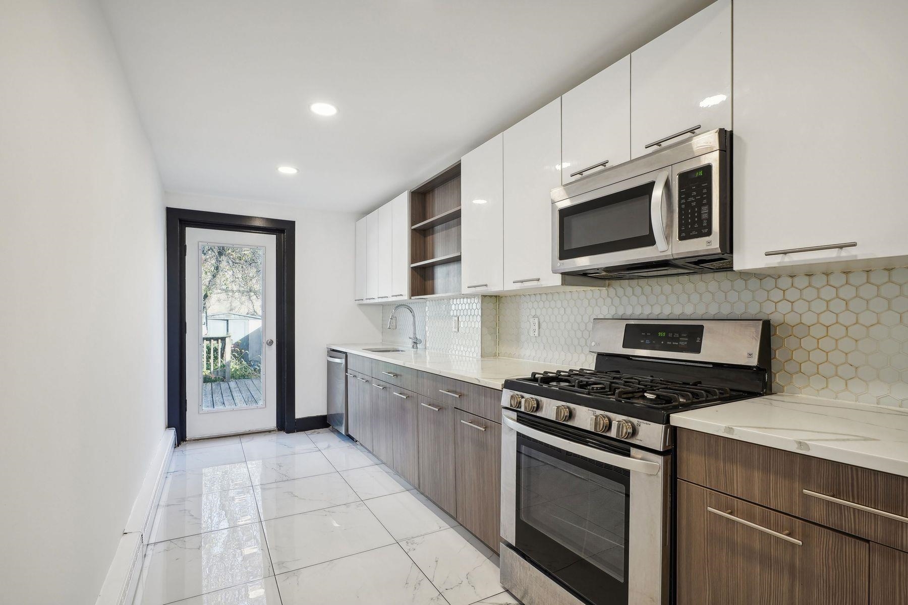 a kitchen with stainless steel appliances granite countertop a stove microwave and cabinets