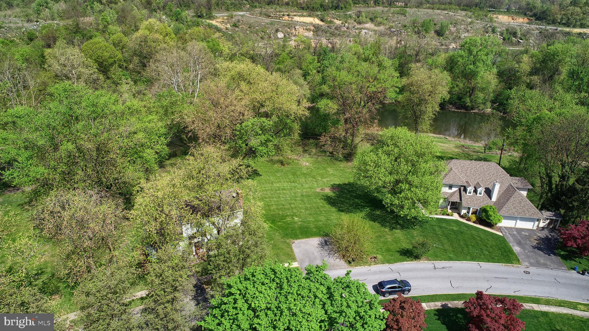 an aerial view of residential house with outdoor space and trees all around