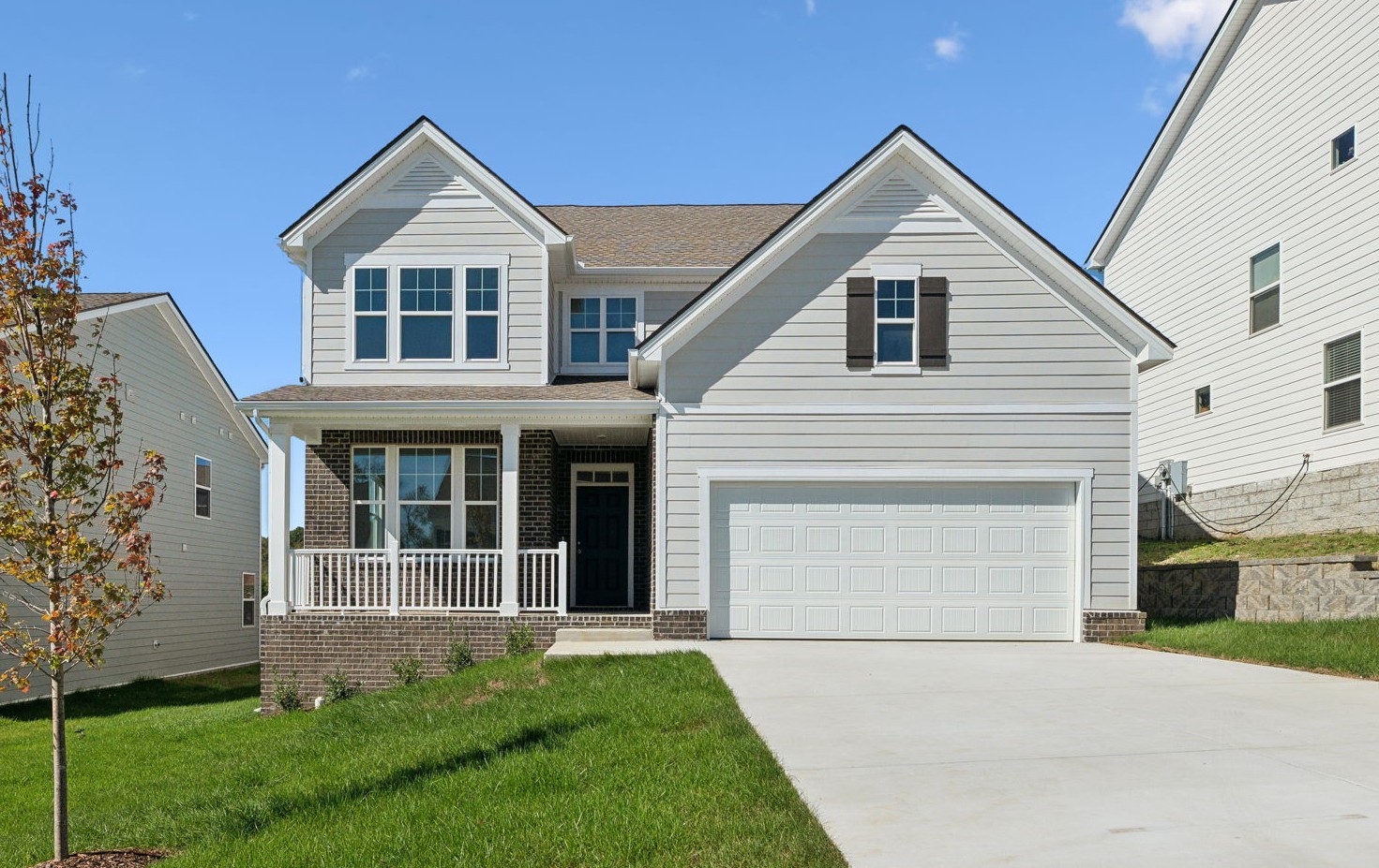 a front view of a house with a yard and trees