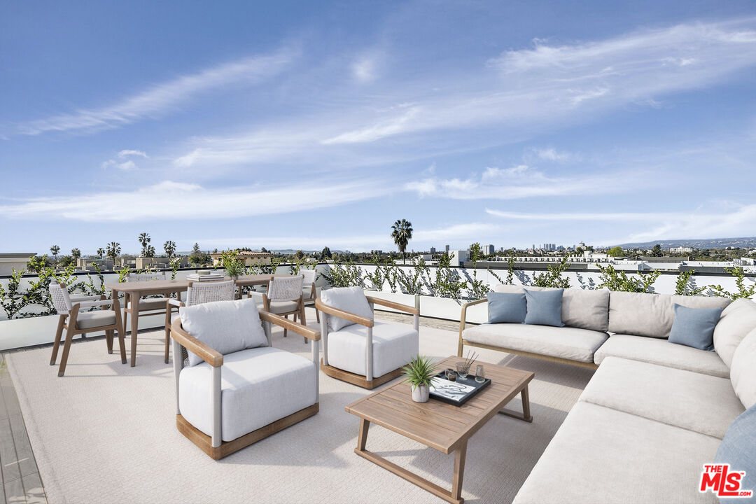 a view of a roof deck with couches and potted plants