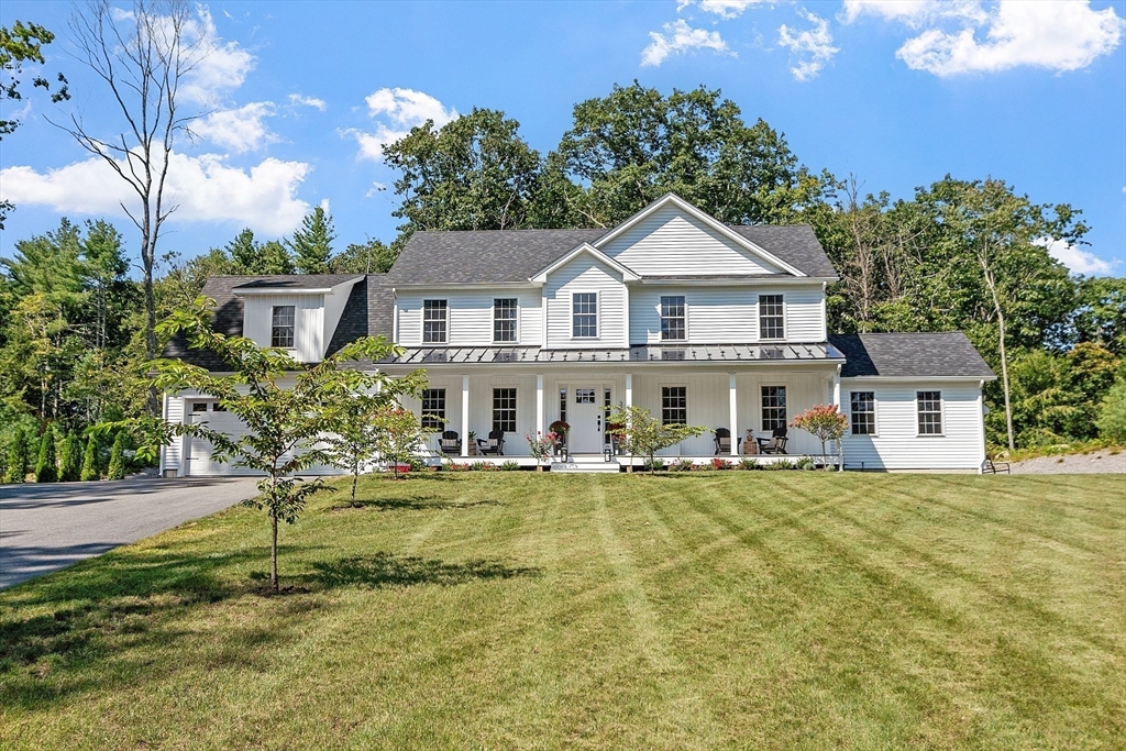 a view of a house with a big yard and large trees