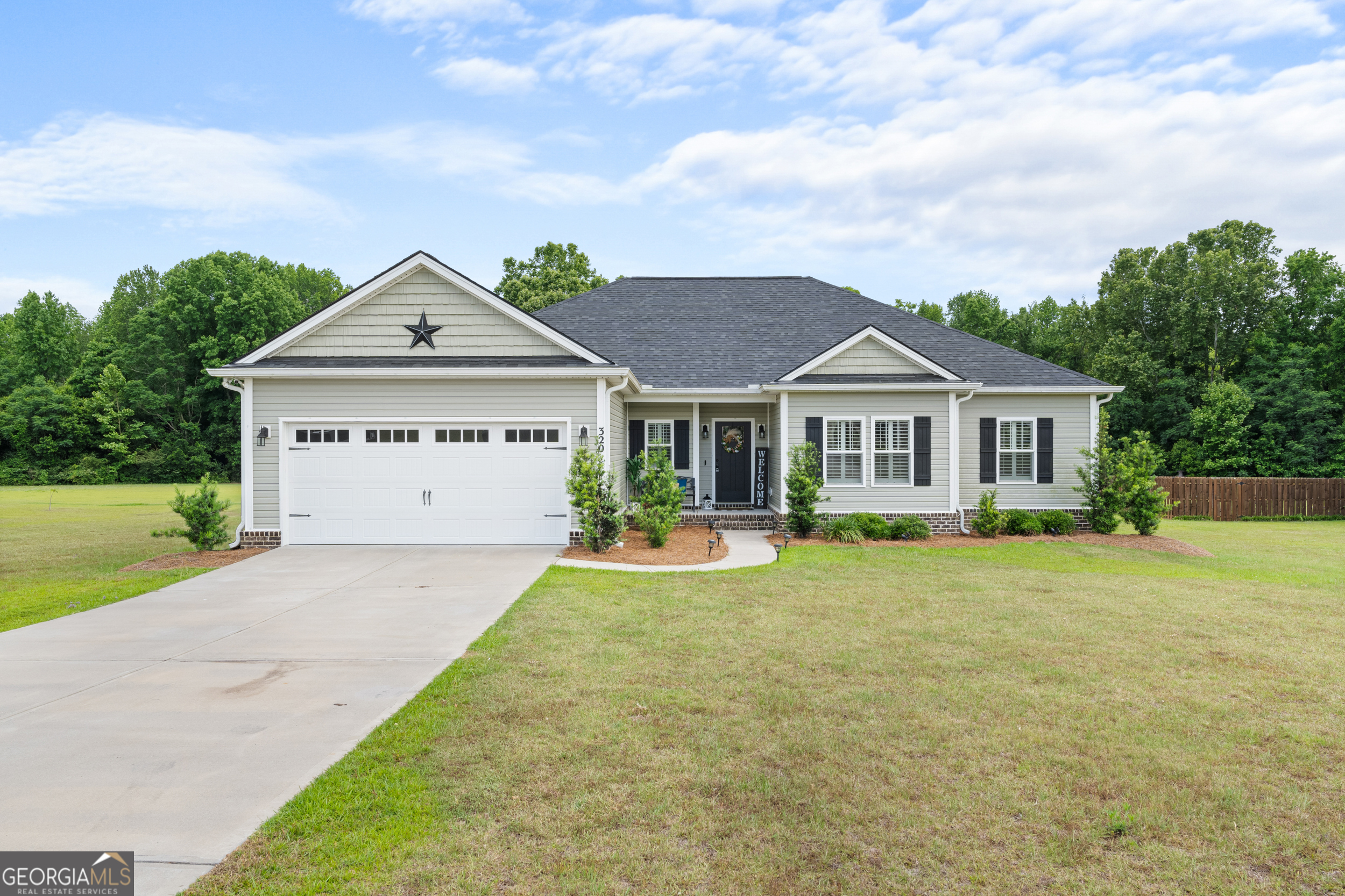 a view of a house with a yard and fence