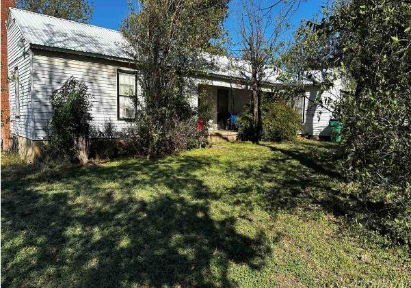 a view of a house with a yard and tree s