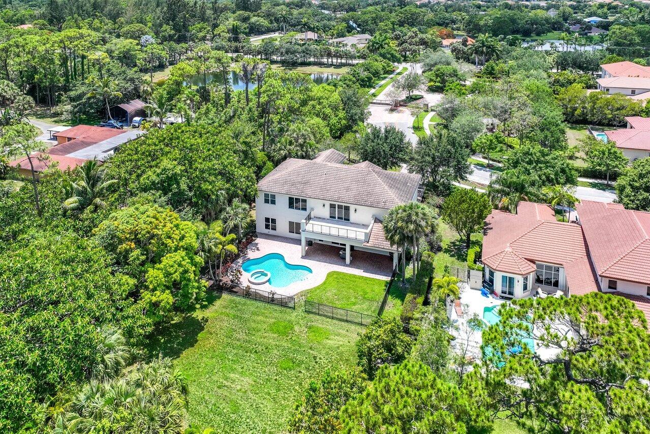 an aerial view of a house with a garden and lake view