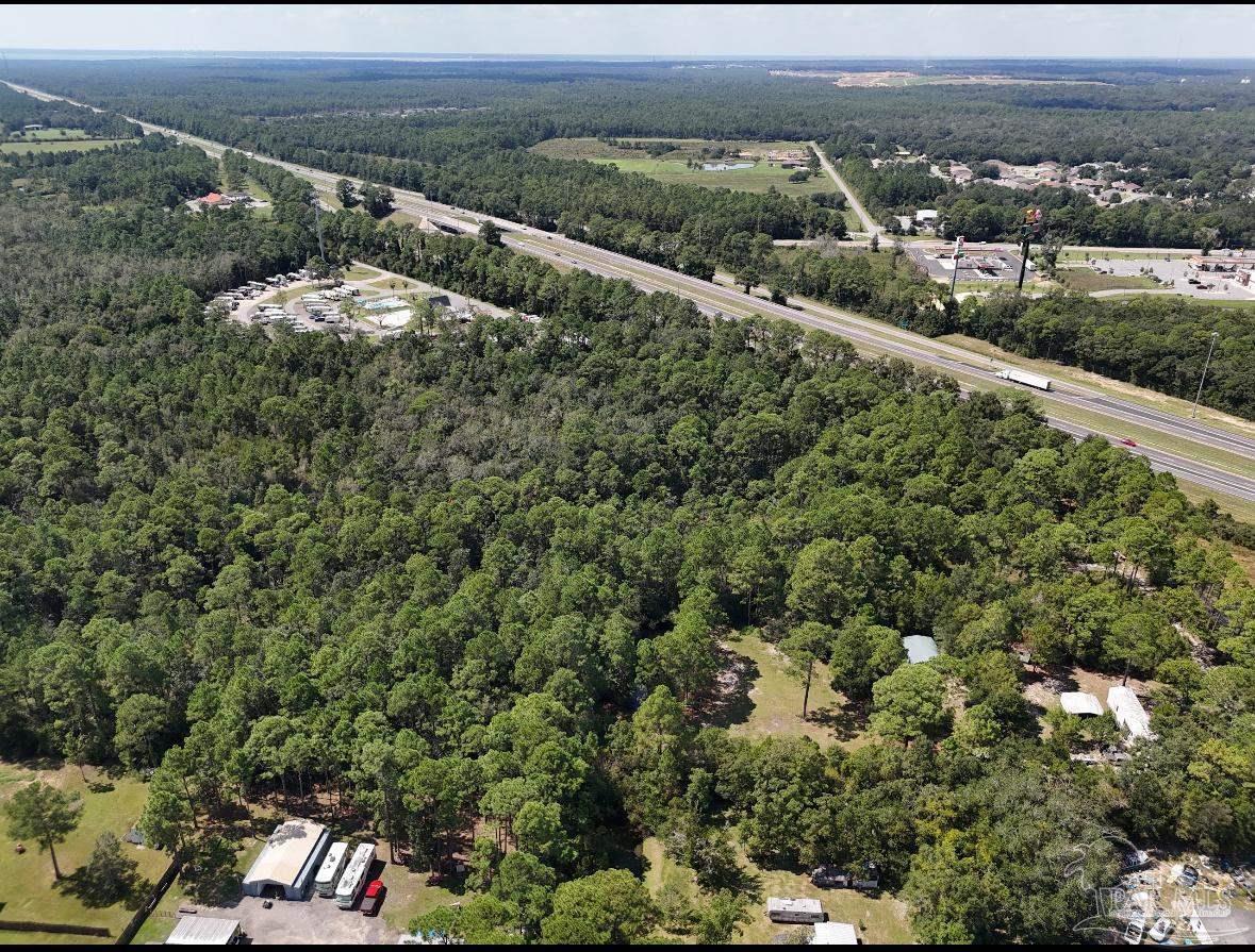 an aerial view of a residential houses covered in trees