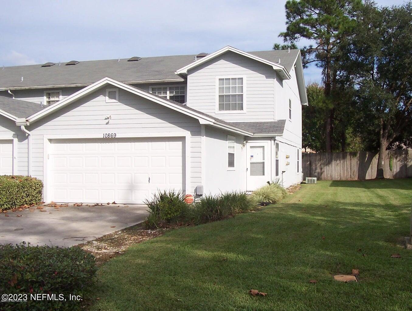 a view of a house with a yard and garage