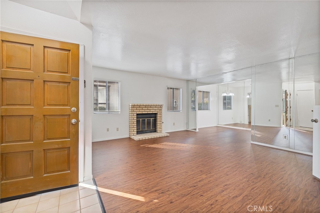 an empty room with windows and fireplace