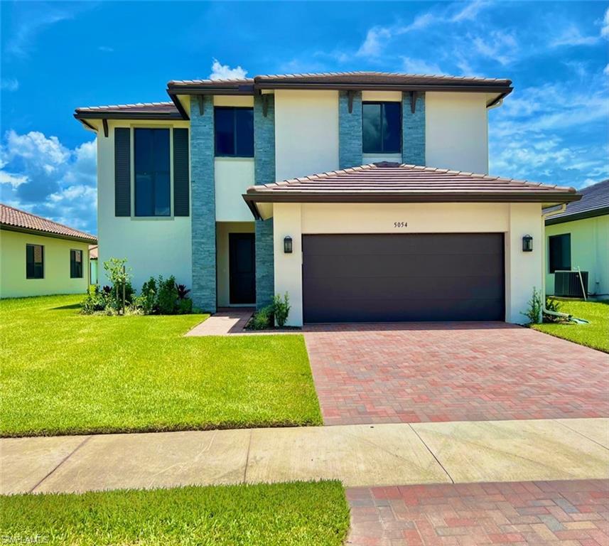 a front view of a house with a yard and garage