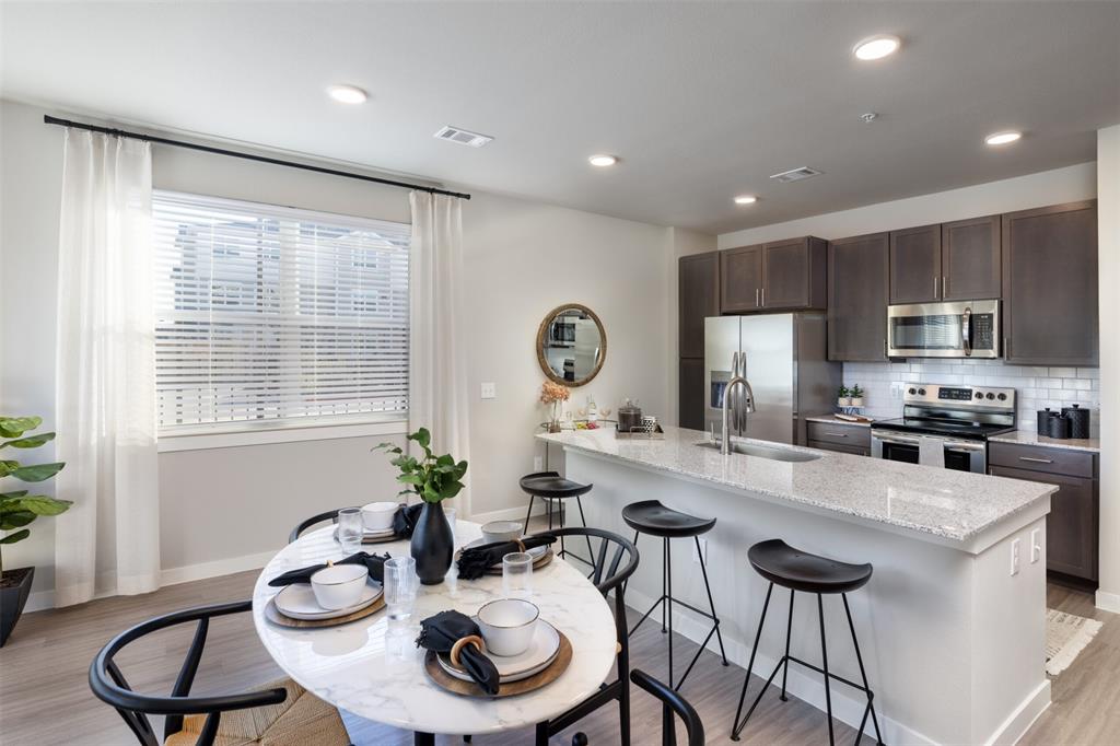 a kitchen with sink refrigerator dining table and chairs