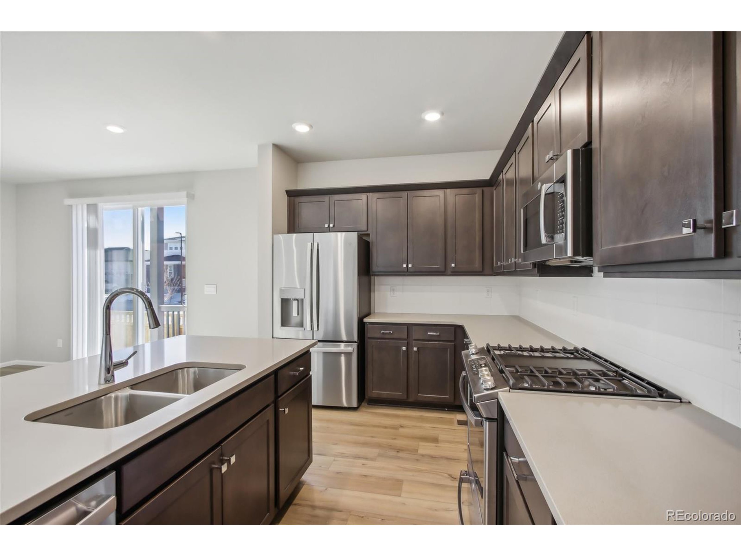 a kitchen with granite countertop a refrigerator and a sink