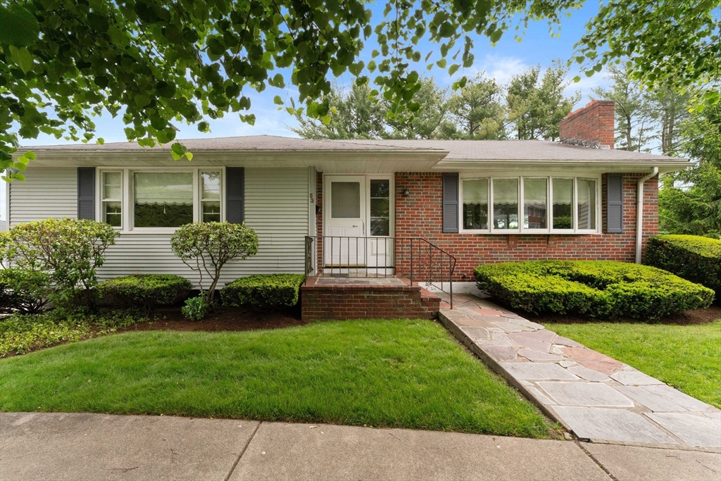 a front view of a house with a garden and yard