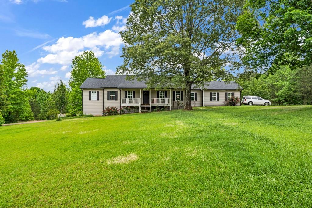 a view of house with yard and outdoor seating