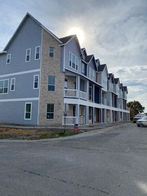 a front view of a building with lot of cars