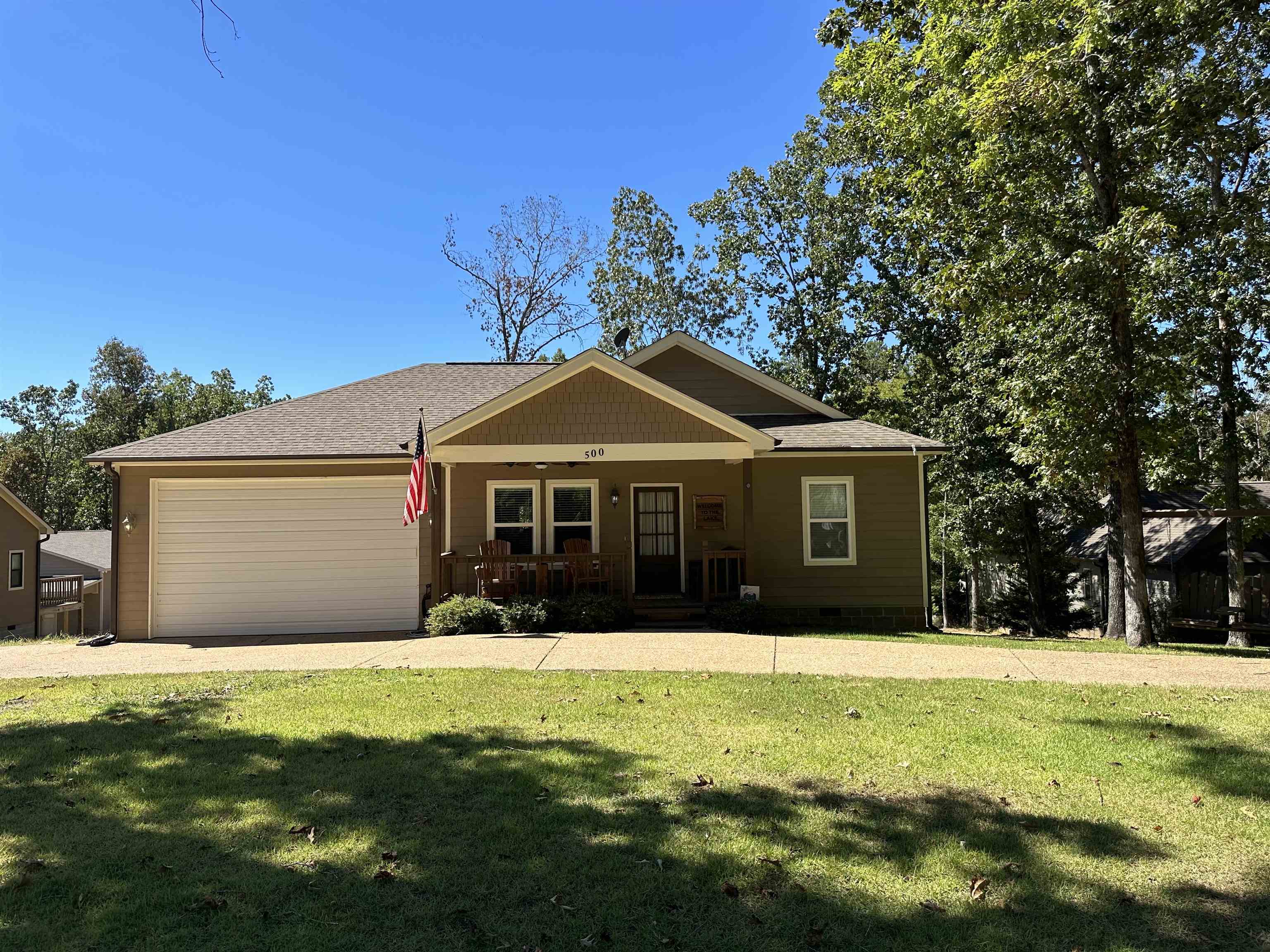 a front view of house with yard and trees in the background