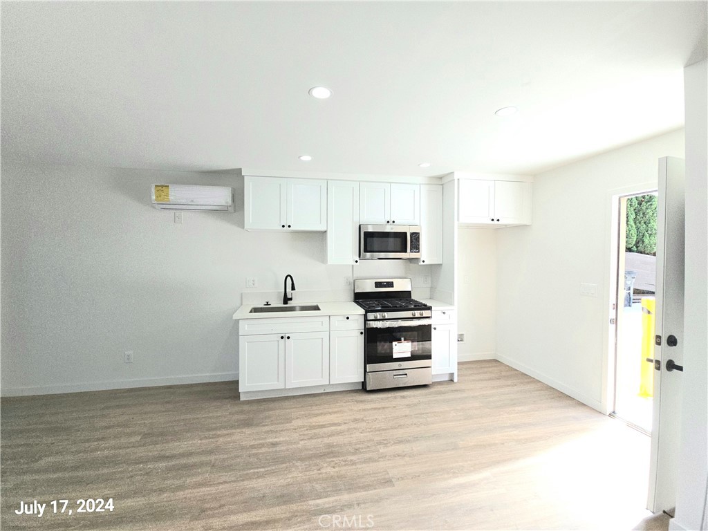 a kitchen with stainless steel appliances a stove top oven a refrigerator and a sink