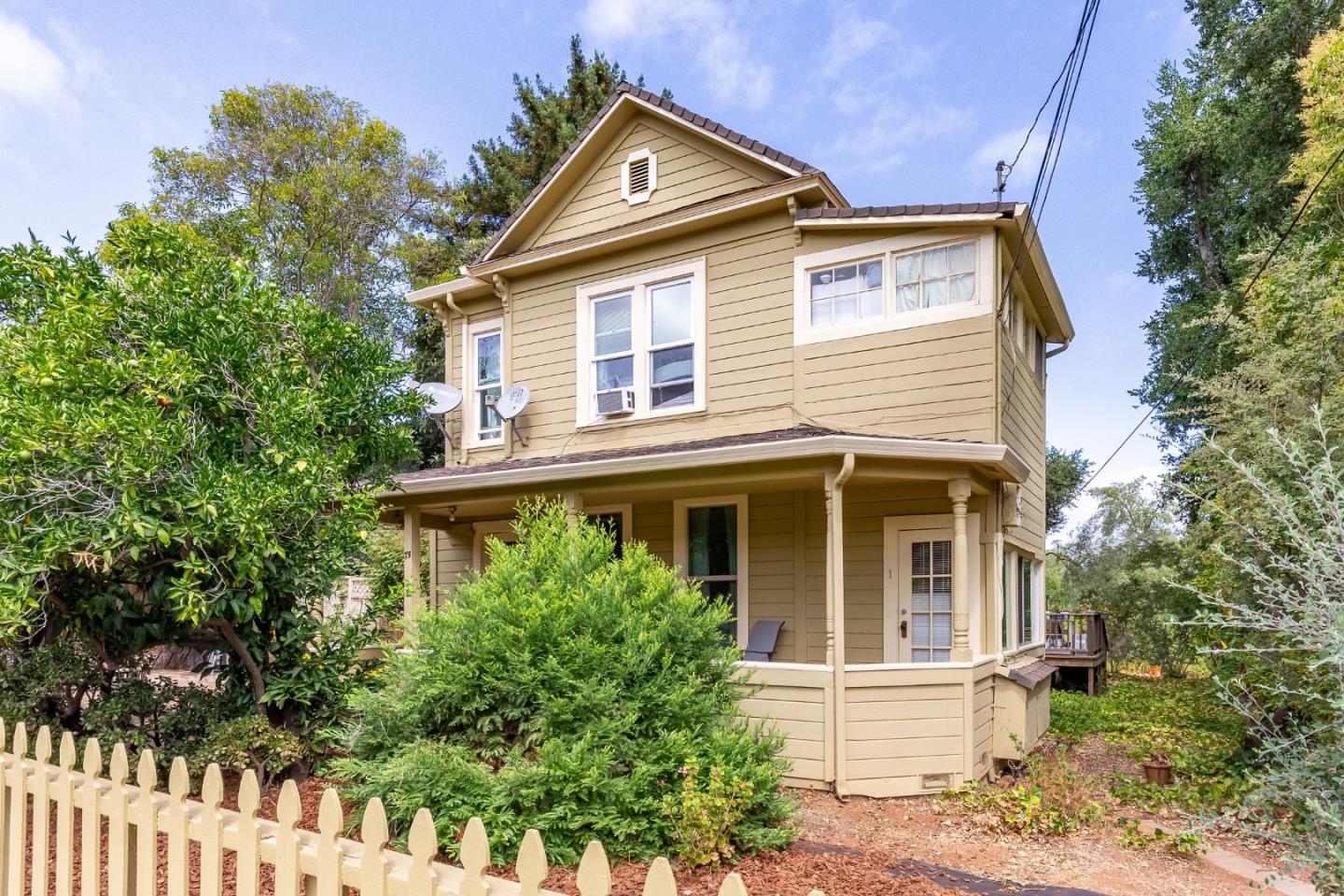 a front view of a house with a yard and trees