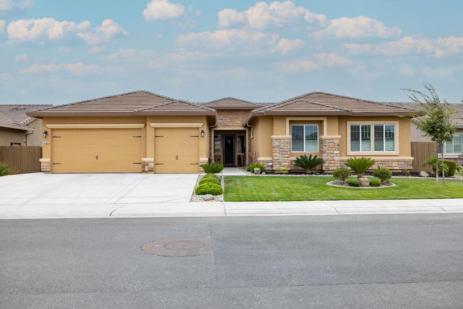 a front view of a house with a yard and garage