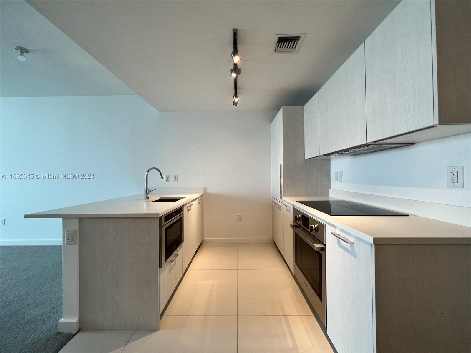 a kitchen with a stove sink and cabinets