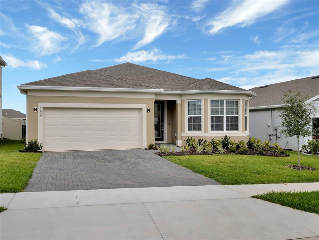 a front view of a house with a yard and garage