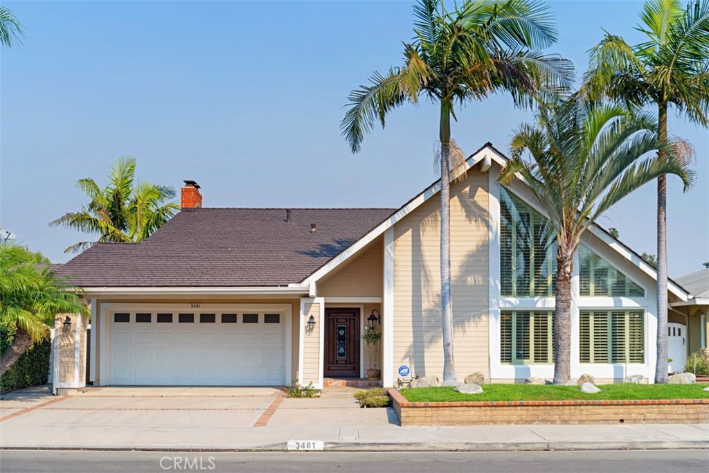 a view of a house with a yard and palm trees