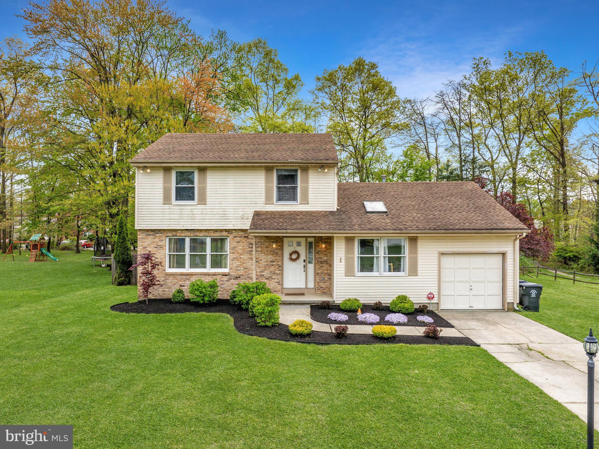 a front view of a house with a garden and yard