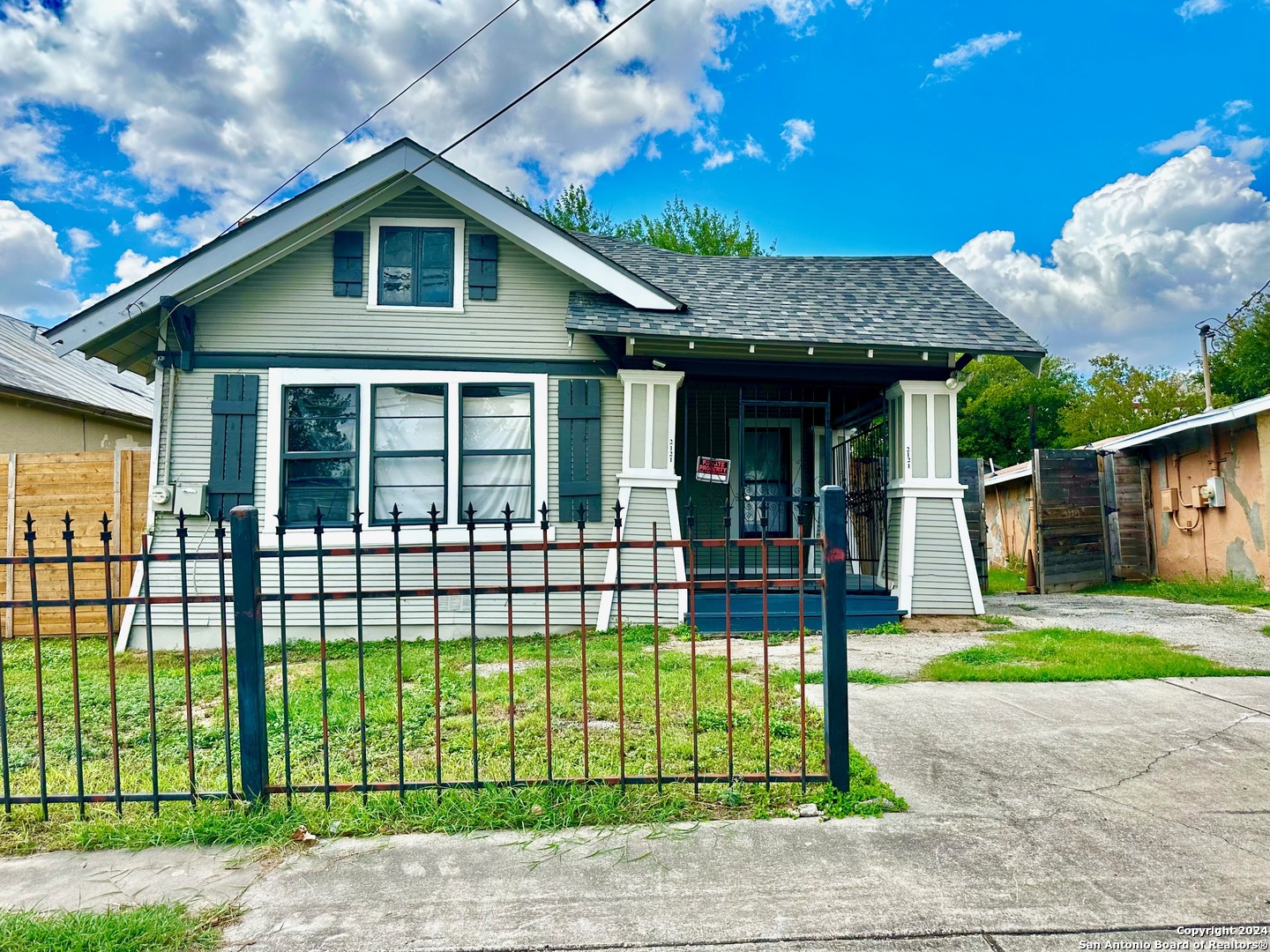 a front view of a house with a garden and plants