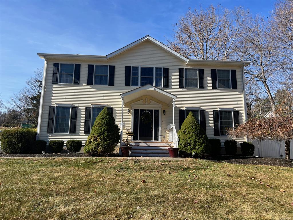 Colonial home with a front yard