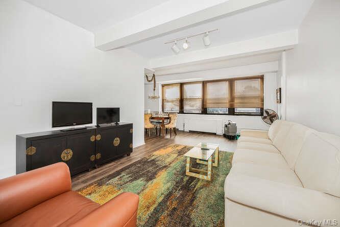 Living room featuring beamed ceiling and wood-type flooring