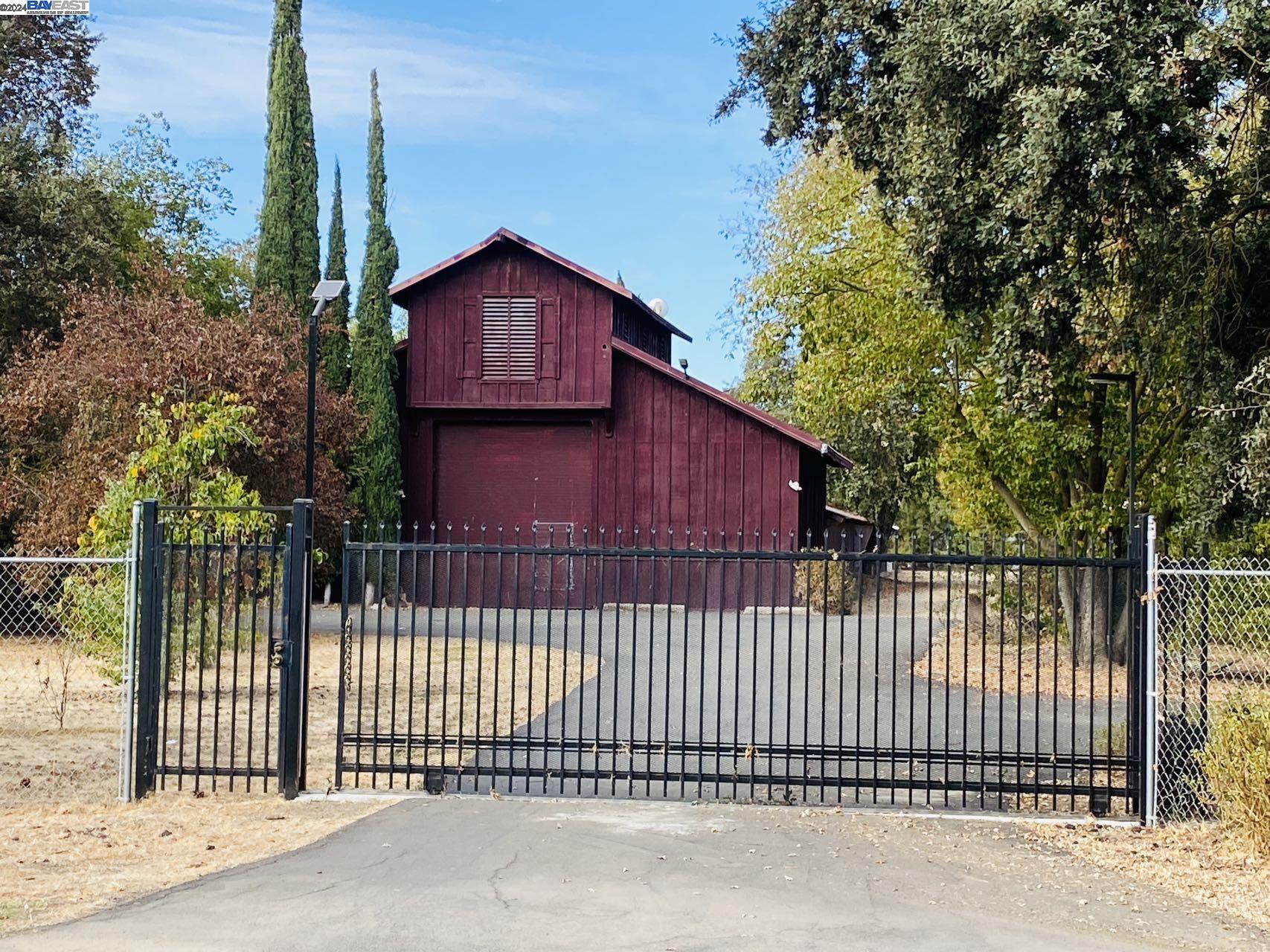 a view of a small house with a small yard and wooden fence