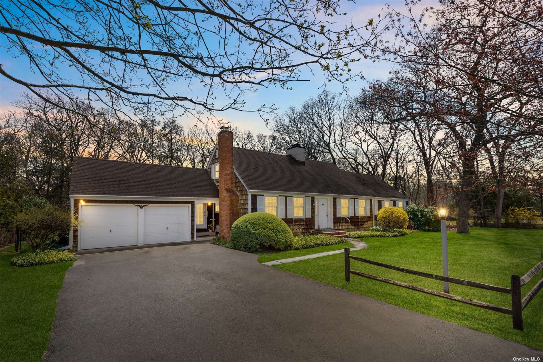 a front view of a house with a yard and trees